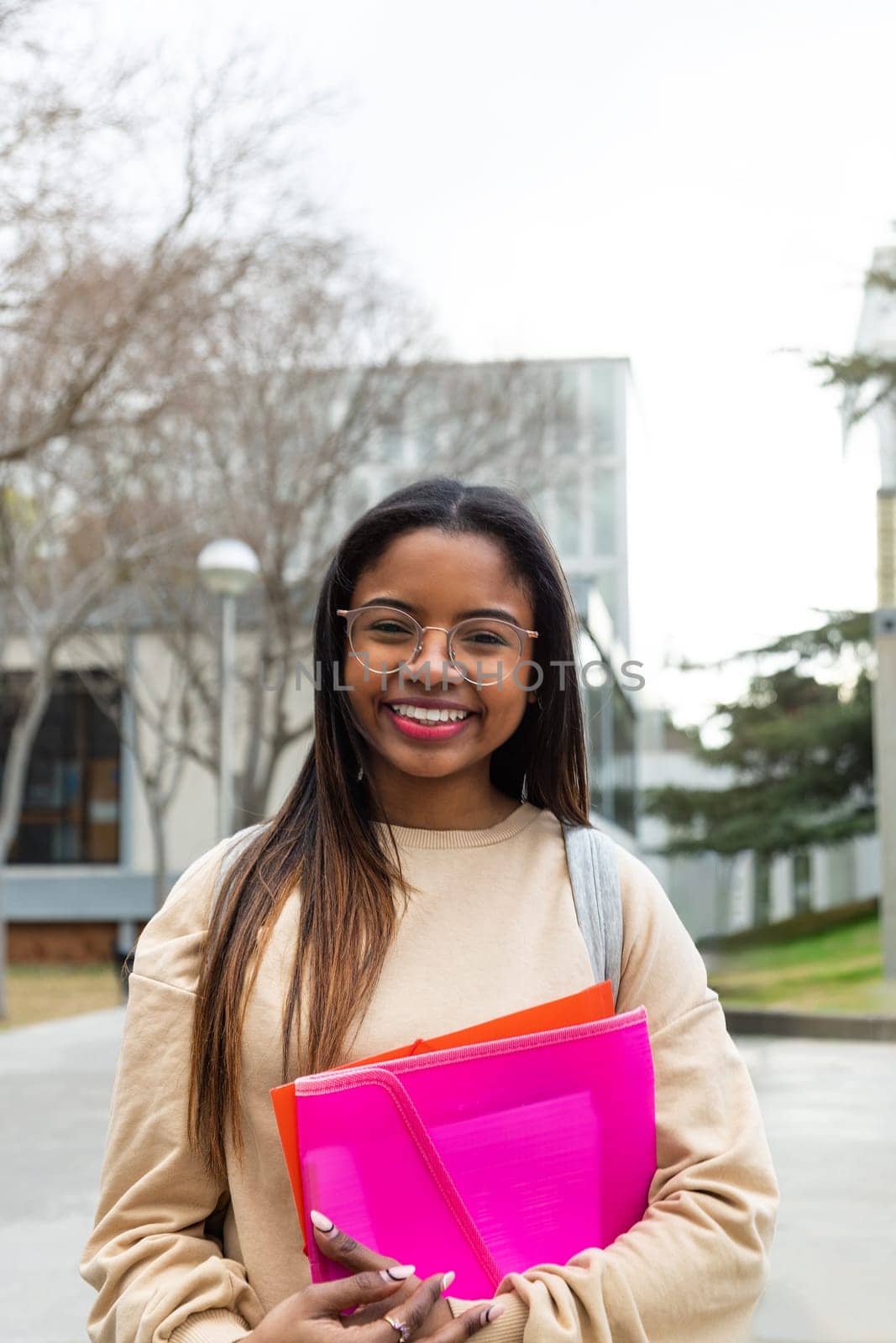 Vertical portrait of happy young black female college student with glasses looking at camera. Copy space. Education and gen z concept.