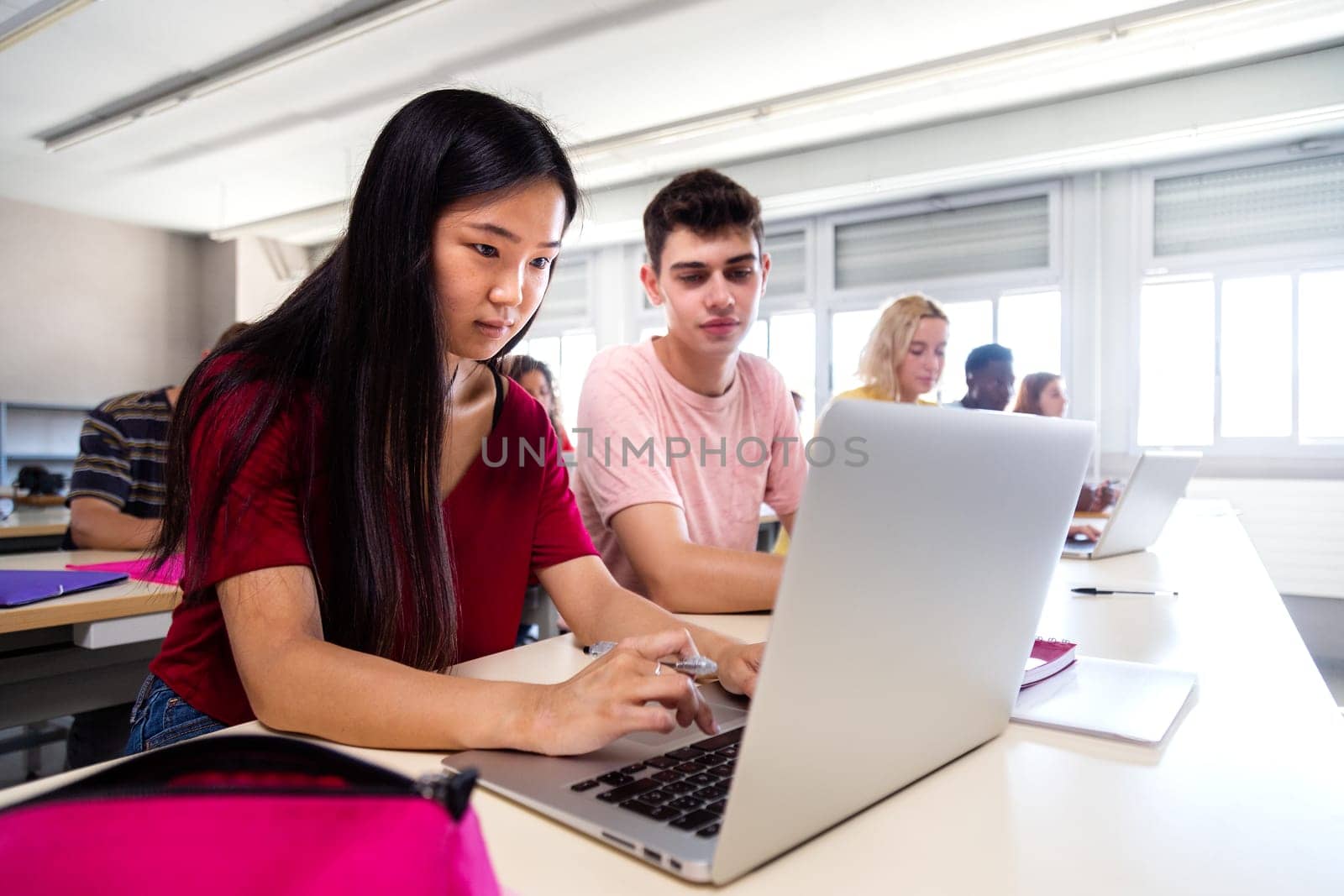 Asian female teen high school student using laptop in class. Education. Back to school. by Hoverstock