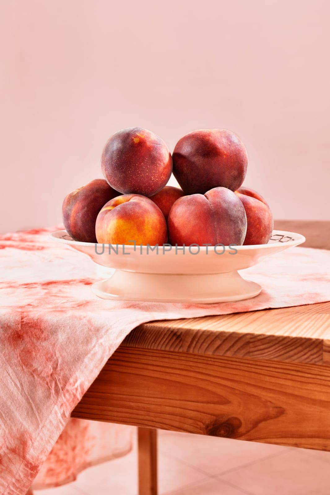 Ripe fruit of peaches in plate  on wooden table , 