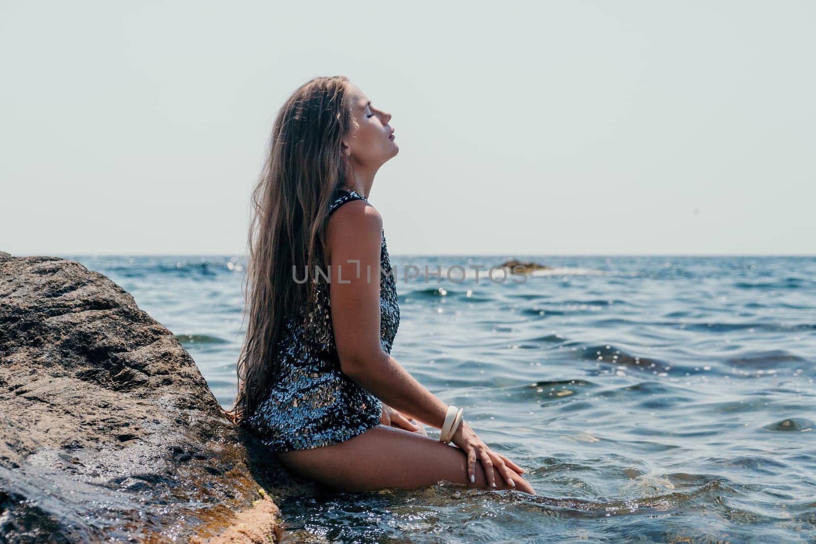 Woman summer travel sea. Happy tourist enjoy taking picture outdoors for memories. Woman traveler posing on the beach at sea surrounded by volcanic mountains, sharing travel adventure journey by panophotograph