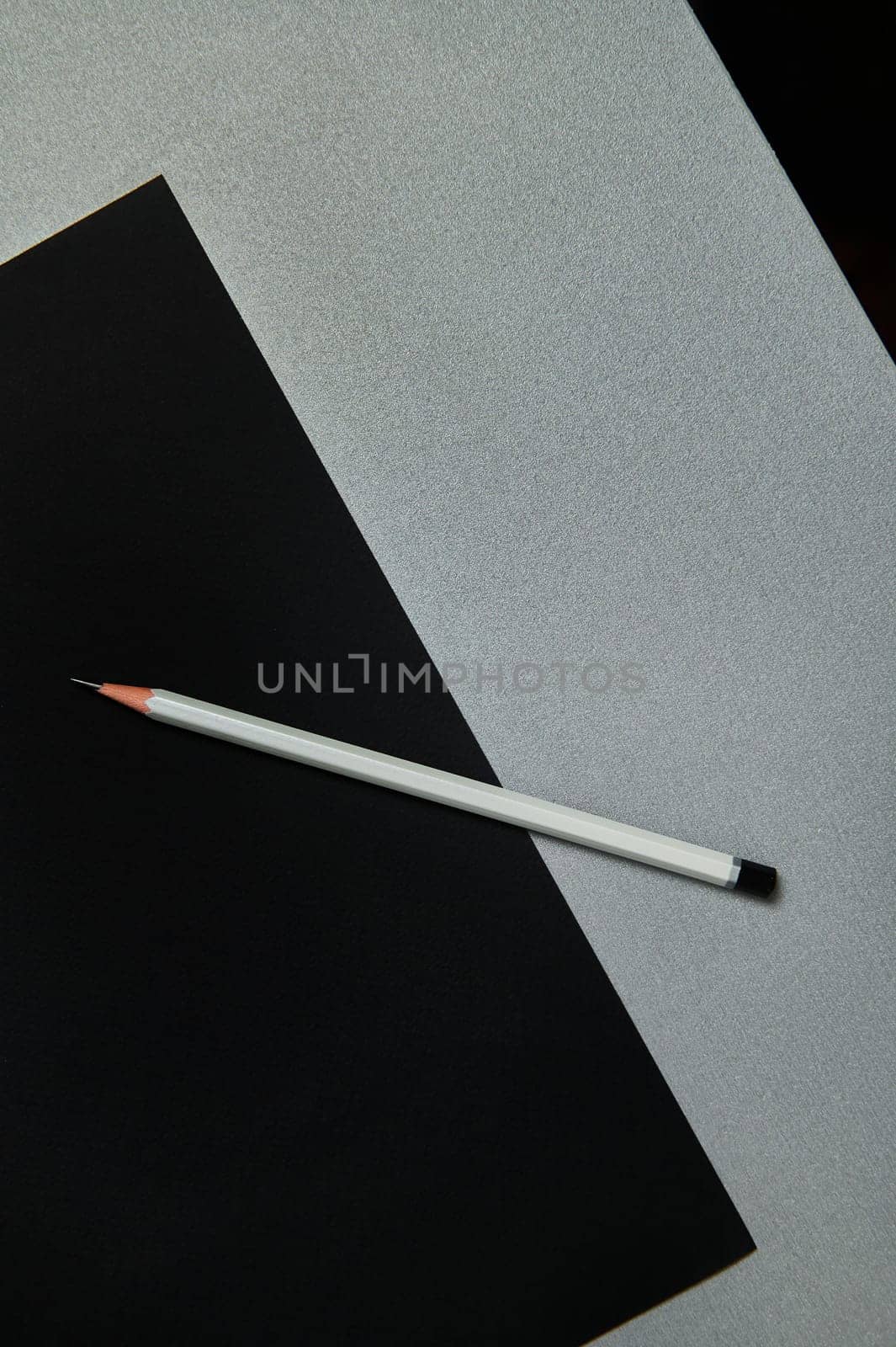 Gray pencil on a black paper on a gray background.