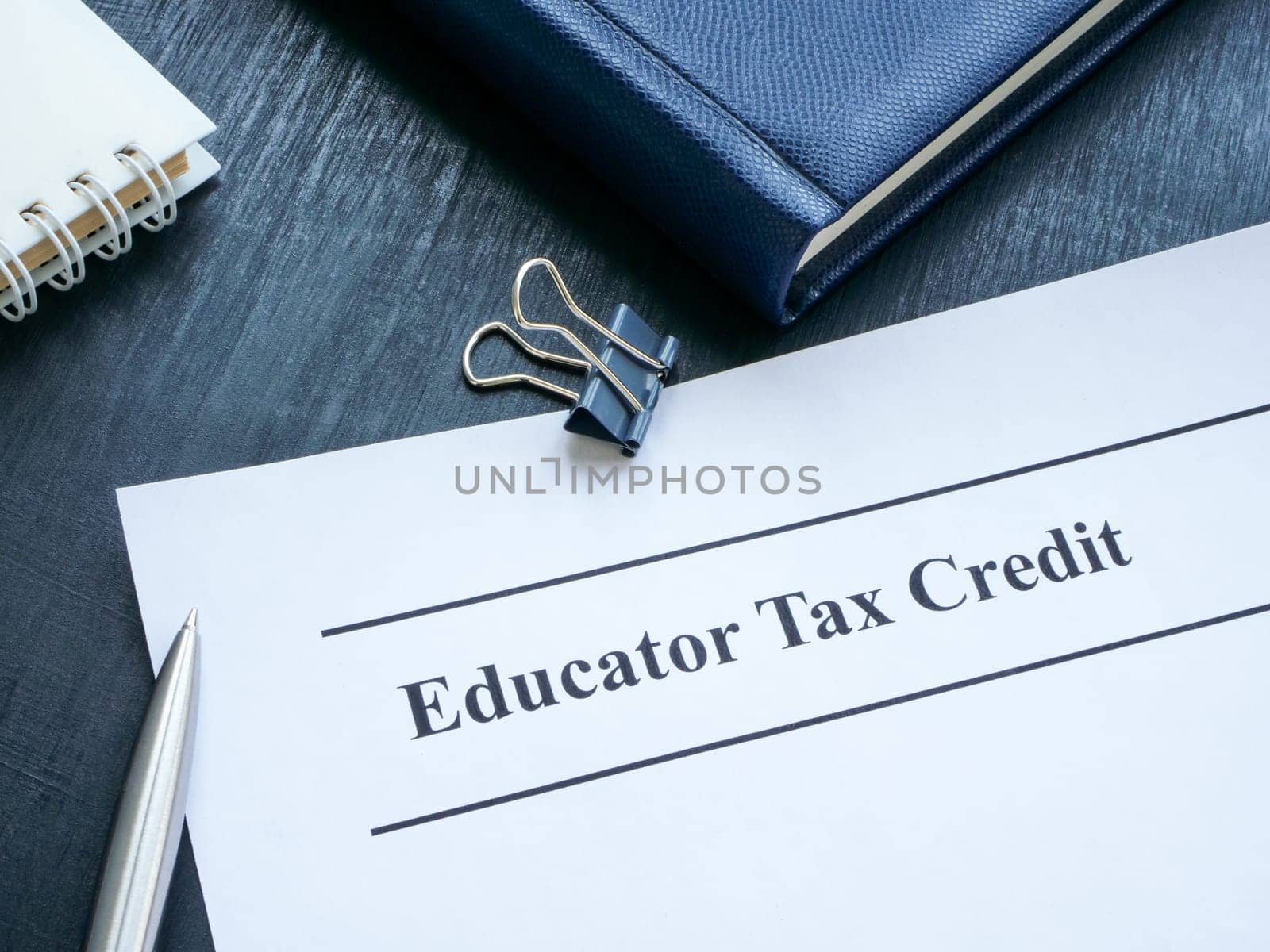 Papers about Educator tax credit on the desk. by designer491