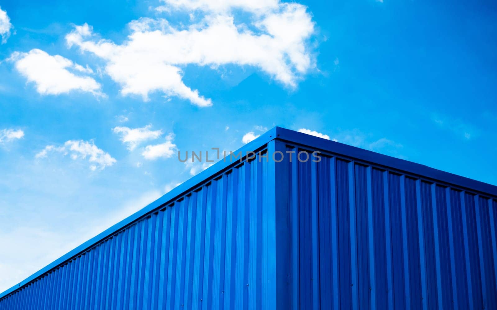 Blue warehouse roof with sky and clouds background by Unimages2527