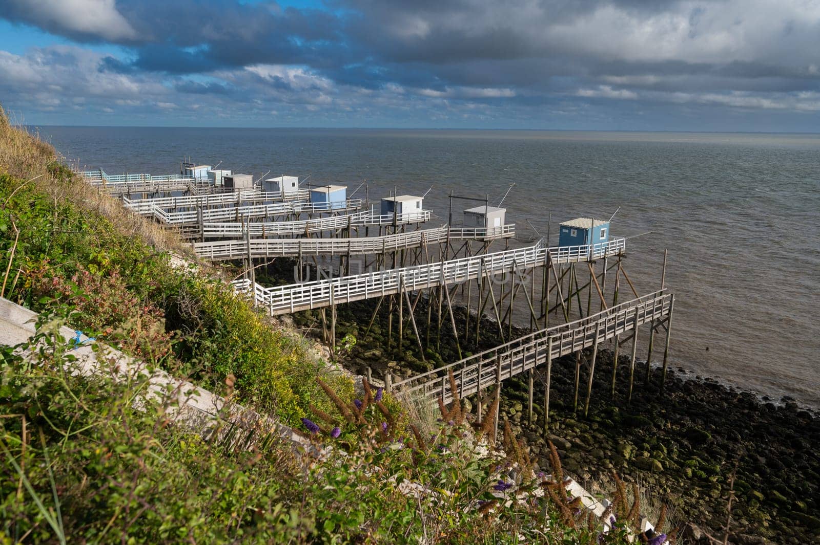 Traditional fisherman's wooden hut at the bottom of the limestone cliff in the estuary of Gironde, Talmont-sur-Gironde, France. High quality photo
