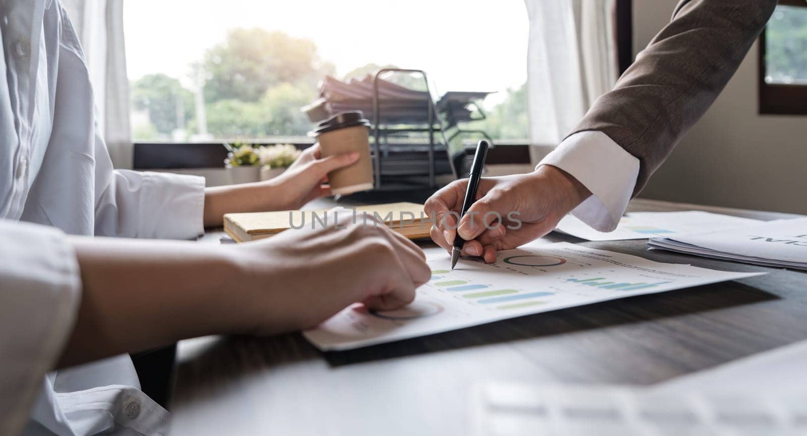 Two Asian business women Discussing Financial reports, analytical concepts, planning and financial statistics and investment markets at the office.