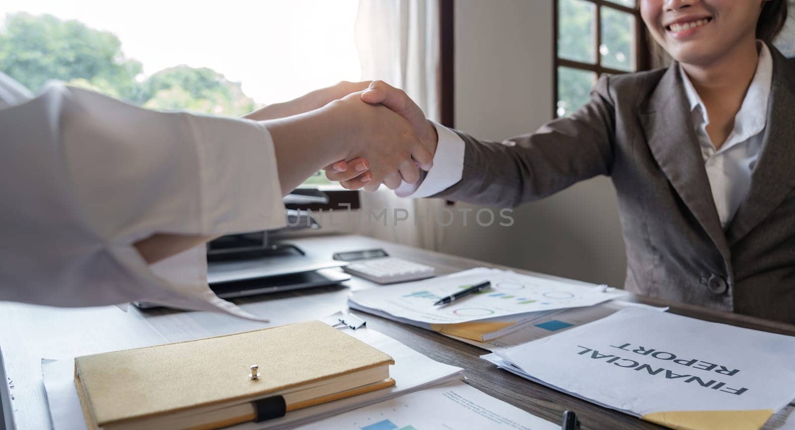 Asian businesswoman shakes hands with a successful woman entrepreneur in the business meeting. woman boss shakes hands and welcomes the new female employee.