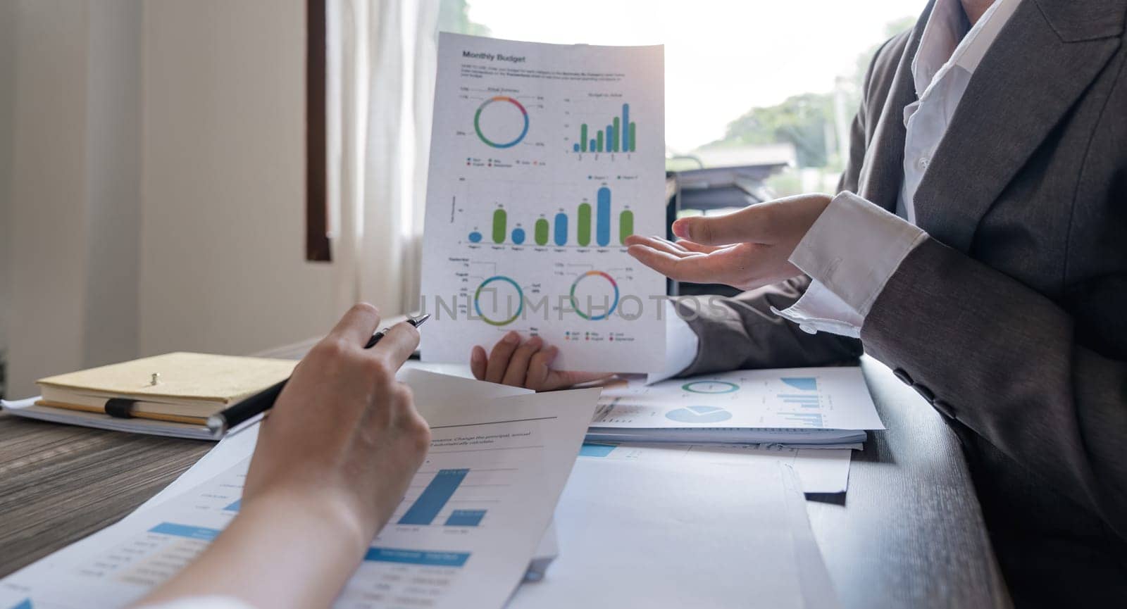 Two businessmen discussion analysis sharing calculations about the company budget and financial planning together on desk at the office room by nateemee