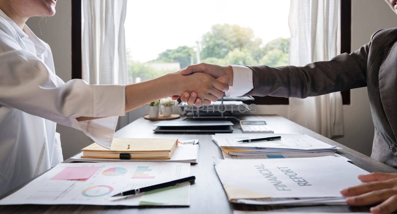 Asian businesswoman shakes hands with a successful woman entrepreneur in the business meeting. woman boss shakes hands and welcomes the new female employee by nateemee