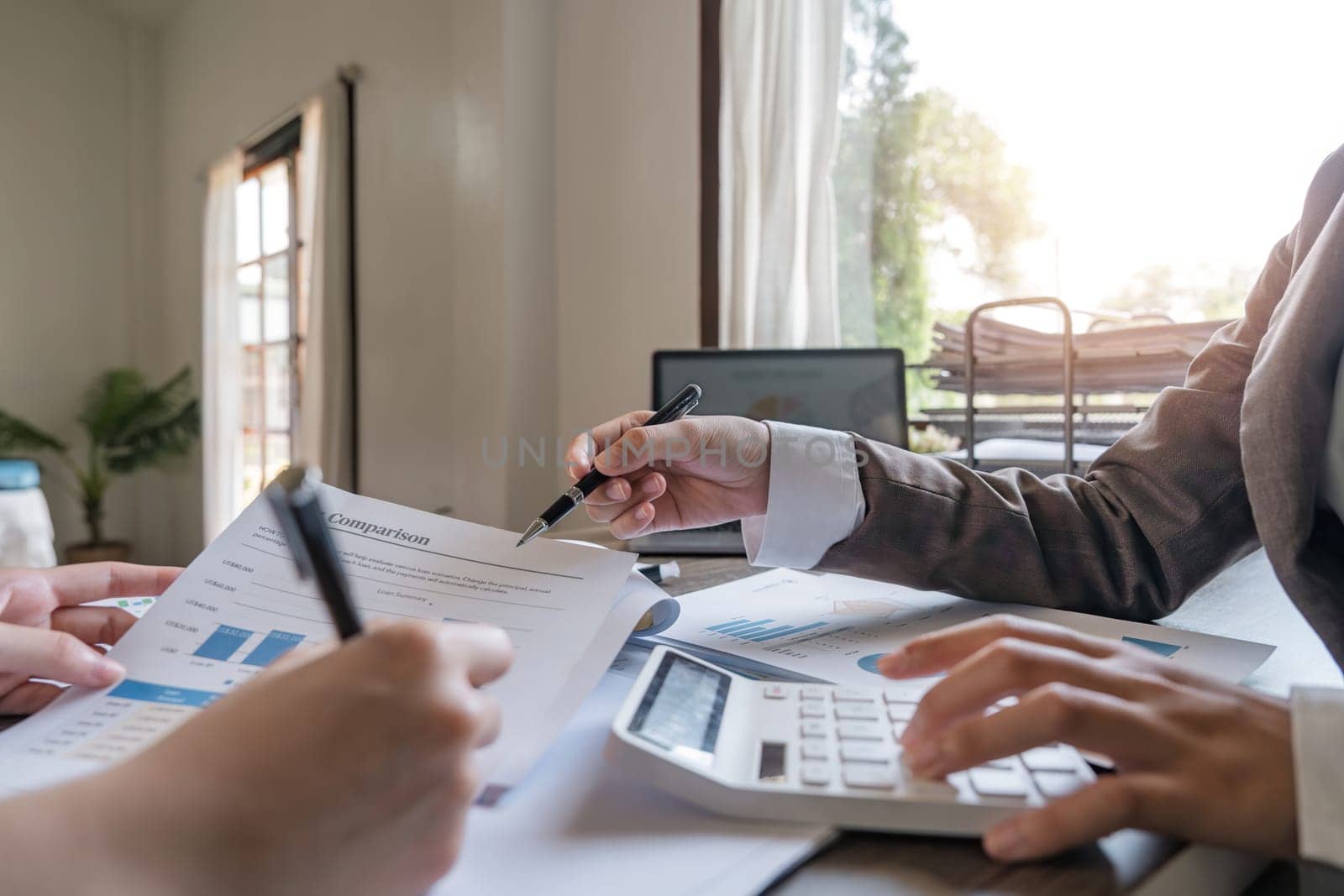 Teamwork of business two colleagues analysis with financial data and marketing report graph, Young business woman two co worker discussing for calculating financial document with calculator.