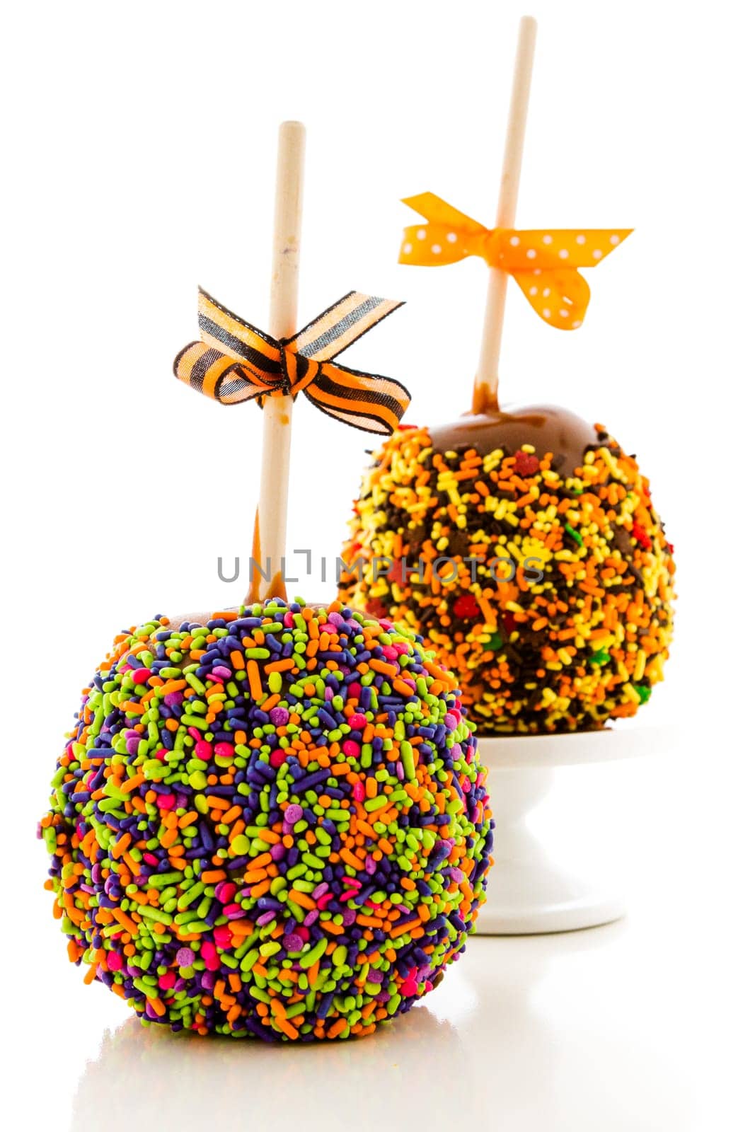 Hand dipped caramel apple covered with multi color sprinkles.