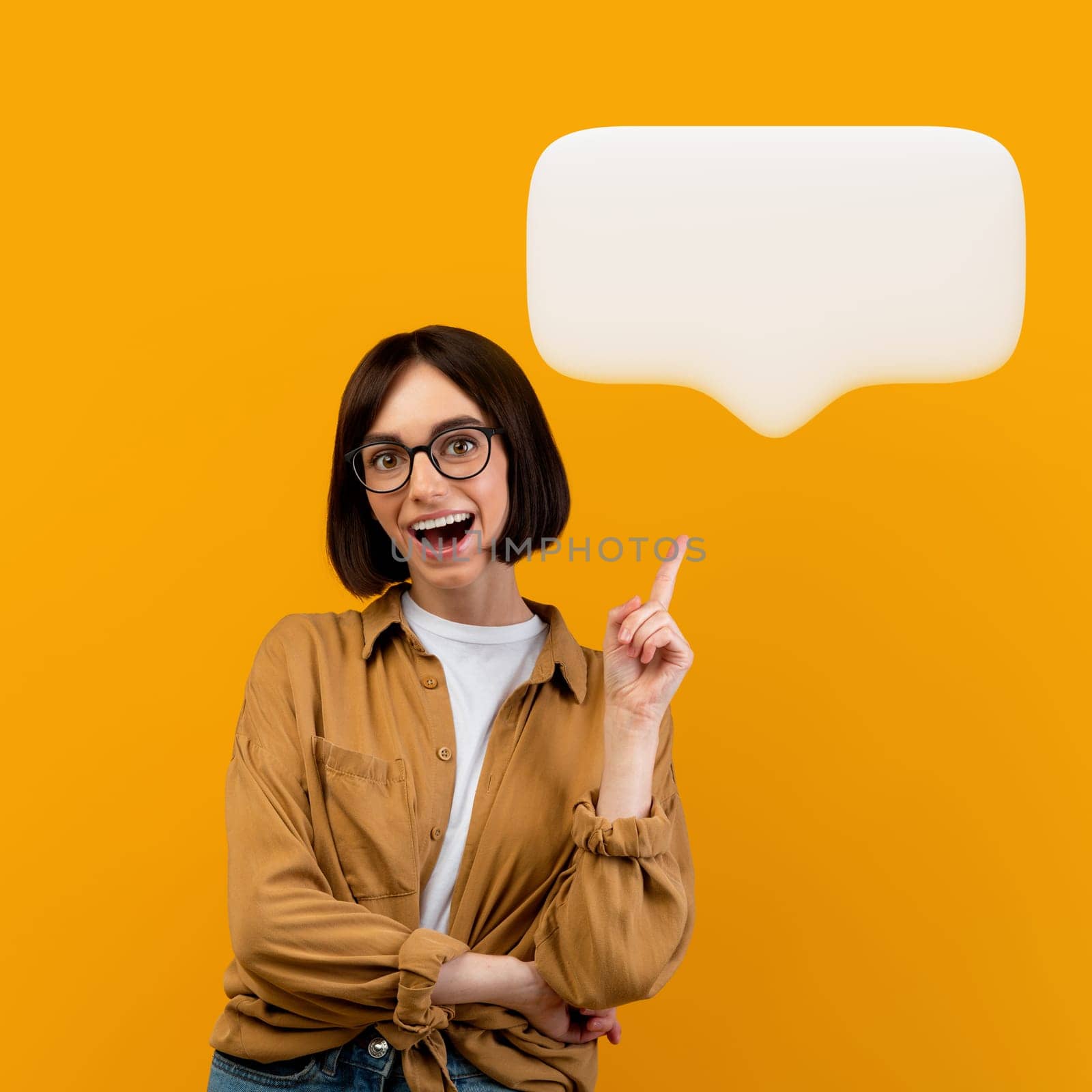 I have an idea. Emotional lady wearing eyeglasses having great thought, finding inspiration or solution to problem, pointing finger up, showing blank communication bubble, posing on yellow background