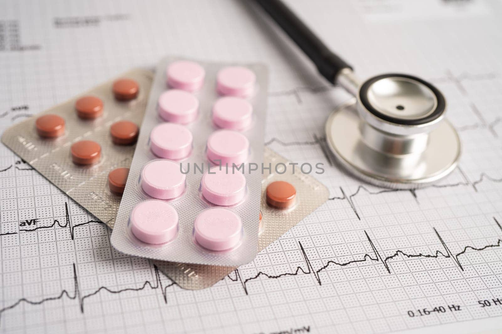 Stethoscope on electrocardiogram ECG with capsule drug, heart wave, heart attack, cardiogram report.