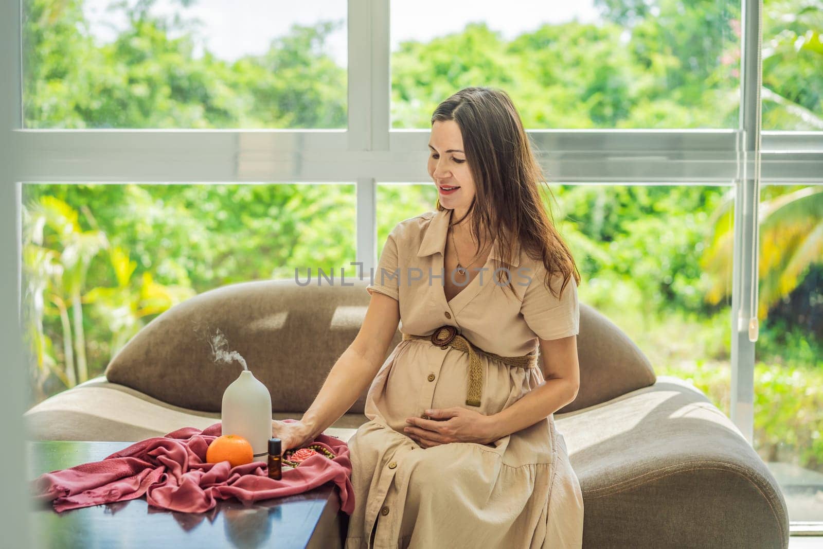 A serene moment captured as a pregnant woman after 40 embraces the soothing benefits of aroma oils and an aroma diffuser, enhancing her pregnancy journey with relaxation and tranquility.