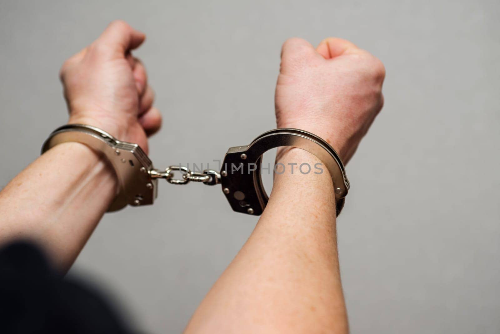 Hands in handcuffs. Prisoner or arrested man , close-up of hands in handcuffs. Male hands in handcuffs.