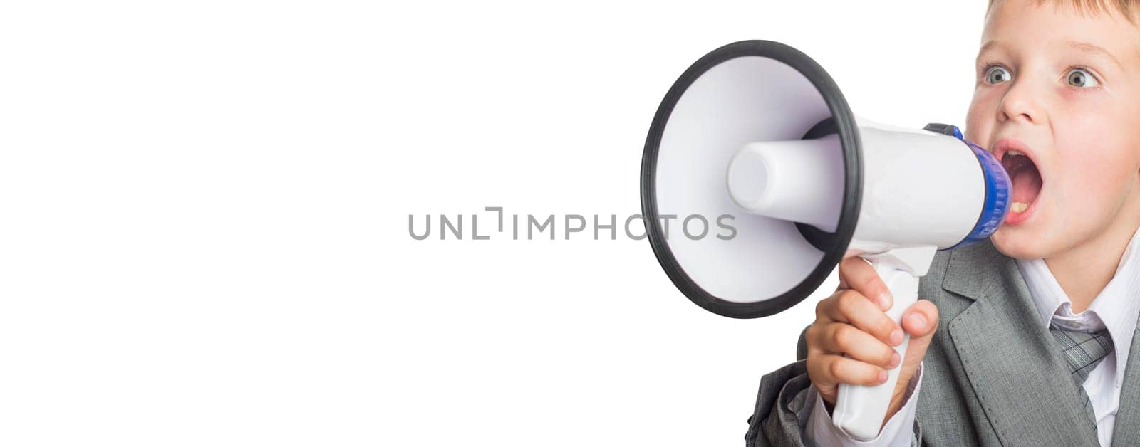 Child businessman holding megaphone. Portrait of a little boy shouting by the megaphone. Child screaming into a megaphone.