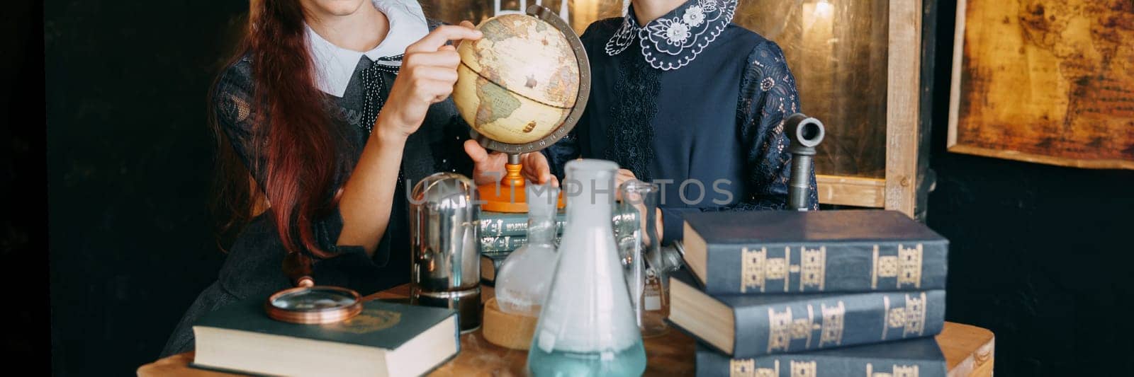 Two schoolgirls perform chemical experiments. Flasks with solutions and chemical formulas on the blackboard in the school classroom. Back to school. School and preschool education.