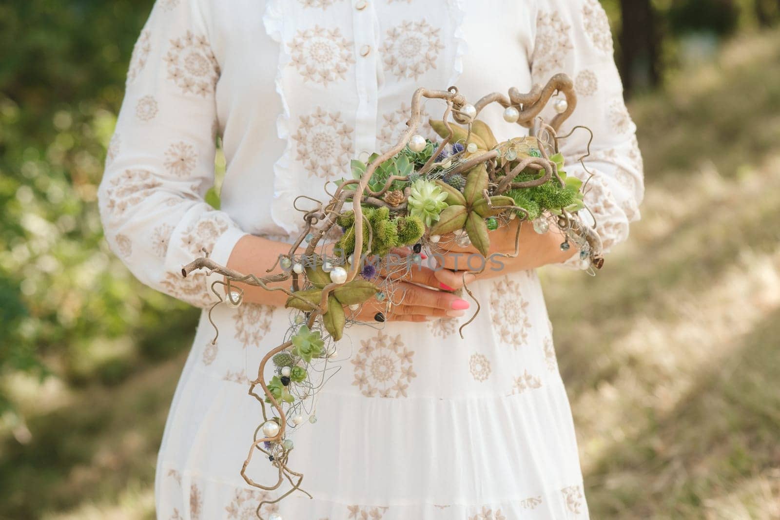 The bride holds an unusual braided wedding bouquet in her hands.