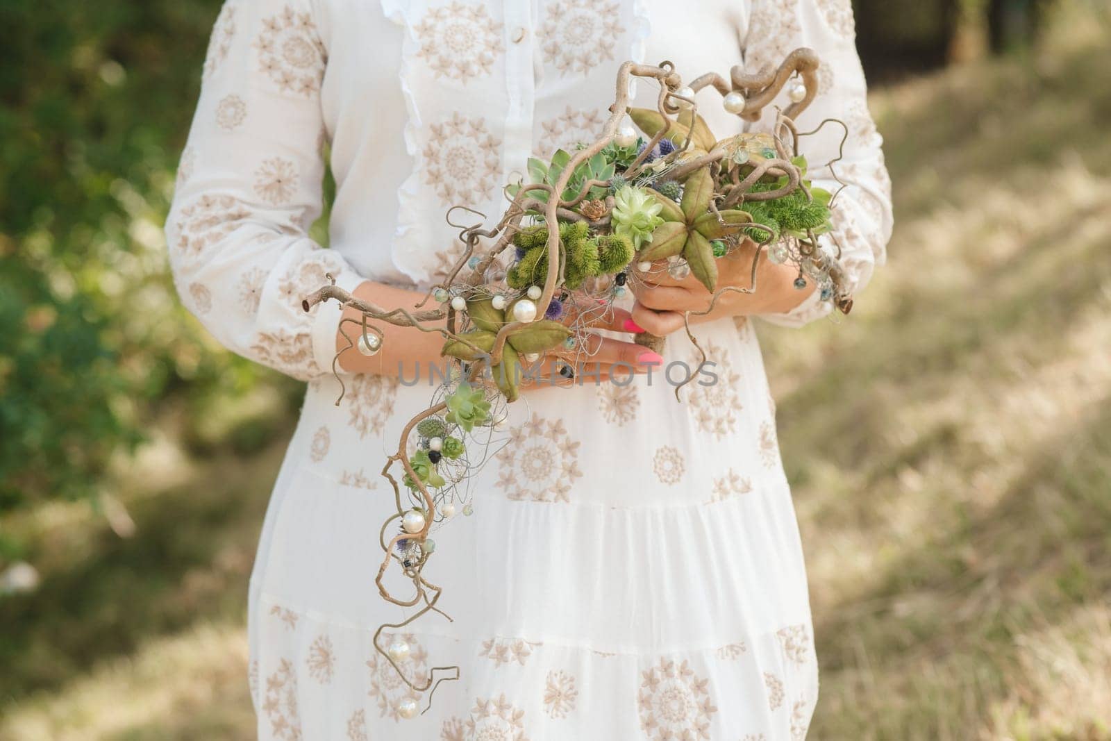 The bride holds an unusual braided wedding bouquet in her hands.