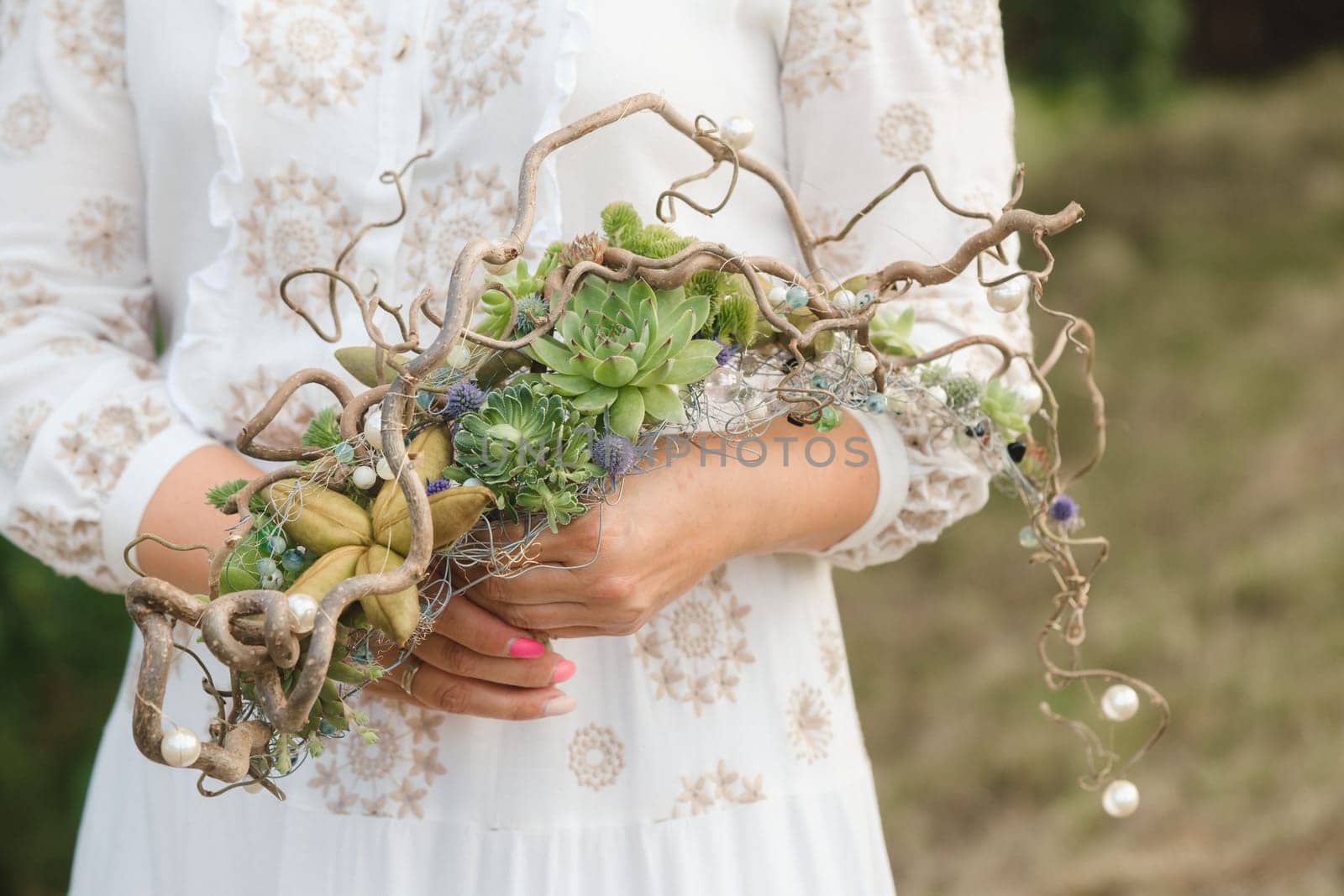 The bride holds an unusual braided wedding bouquet in her hands.