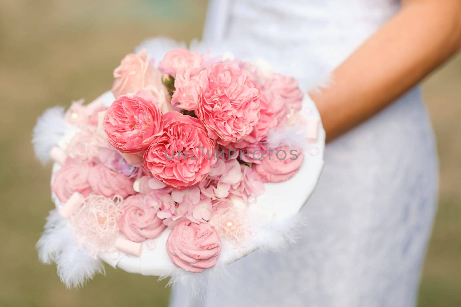 The bride holds her wedding bouquet in her hands.