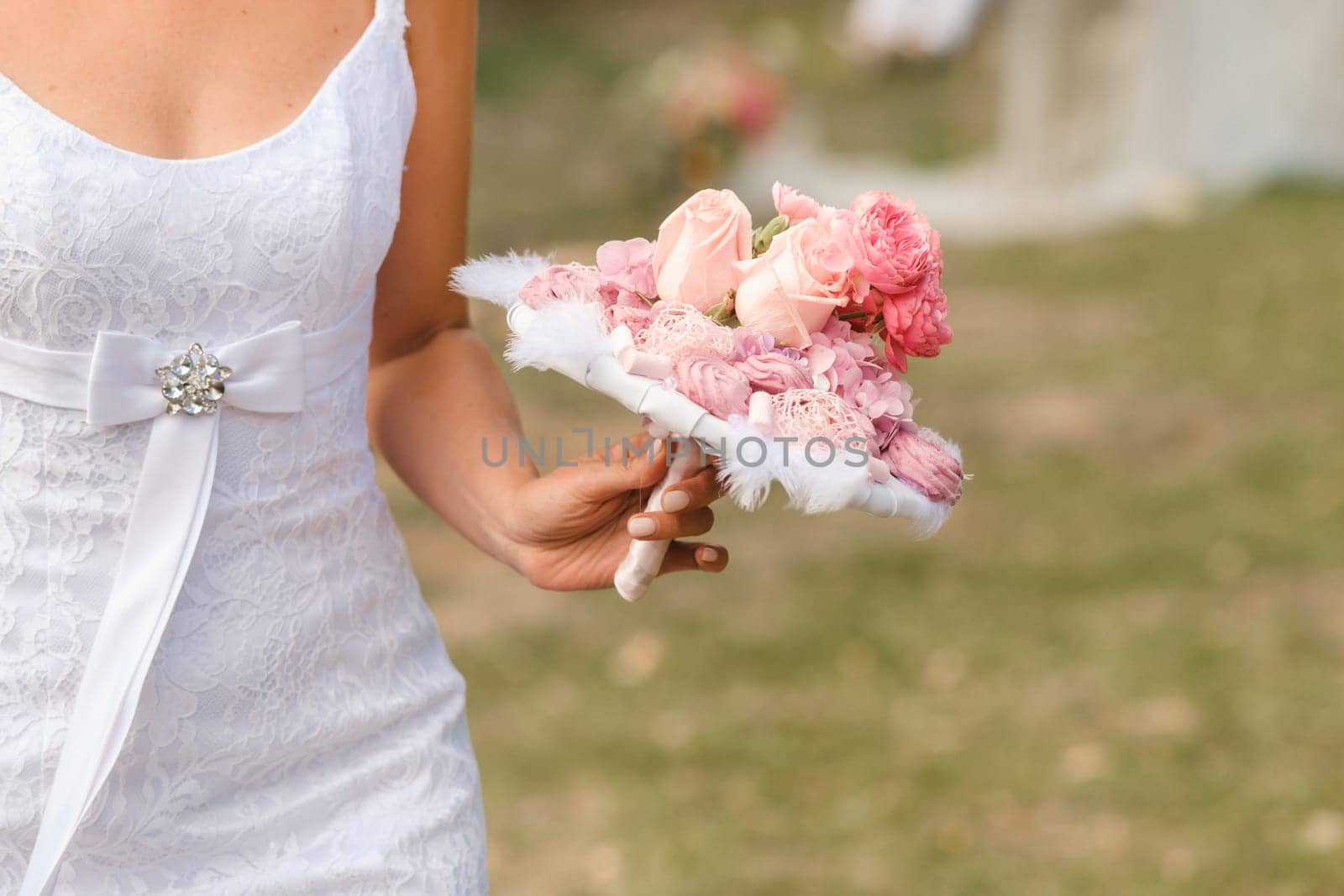 The bride holds her wedding bouquet in her hands.