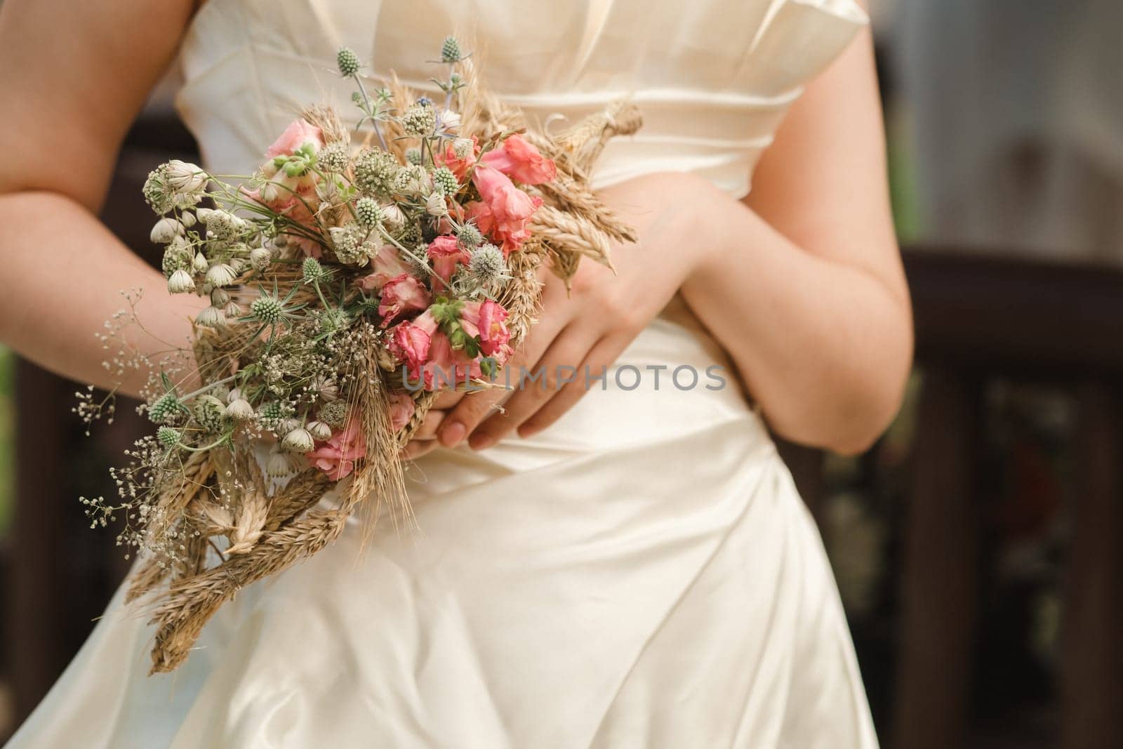 The bride holds her wedding bouquet in her hands.