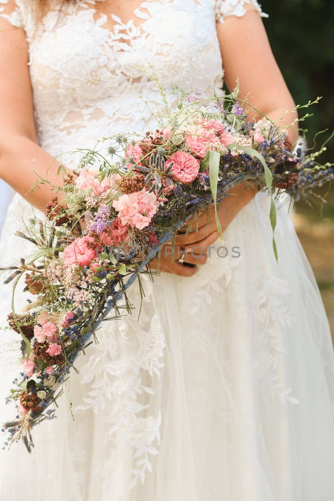 The bride holds her wedding bouquet in her hands.