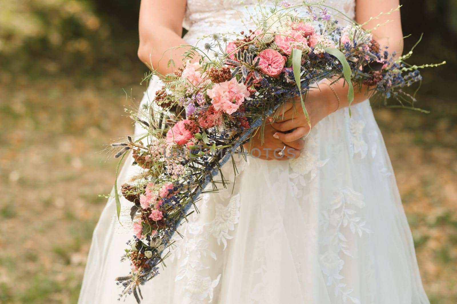 The bride holds her wedding bouquet in her hands.