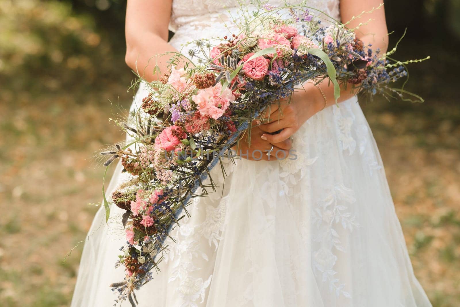 The bride holds her wedding bouquet in her hands.