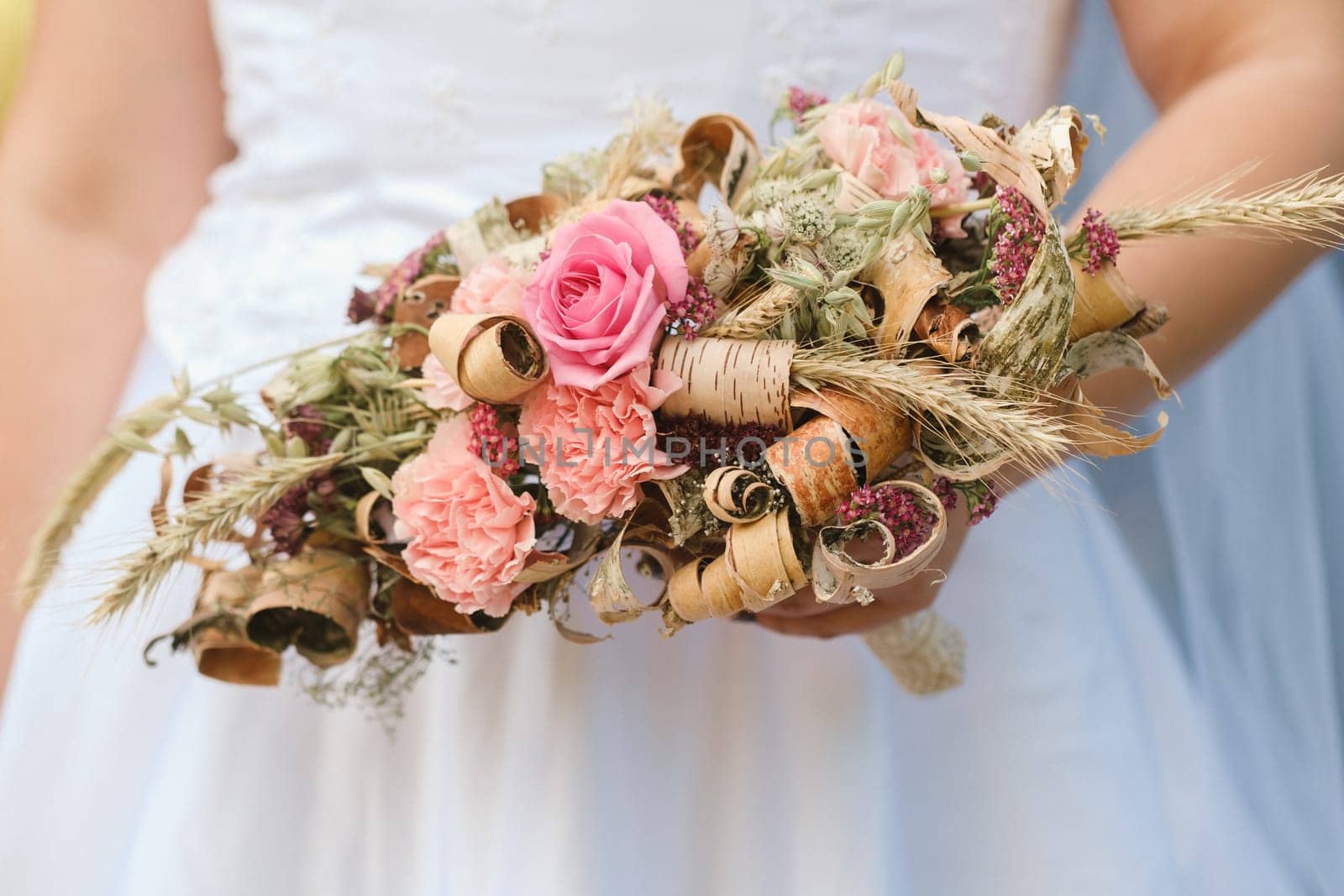 The bride holds her wedding bouquet in her hands.