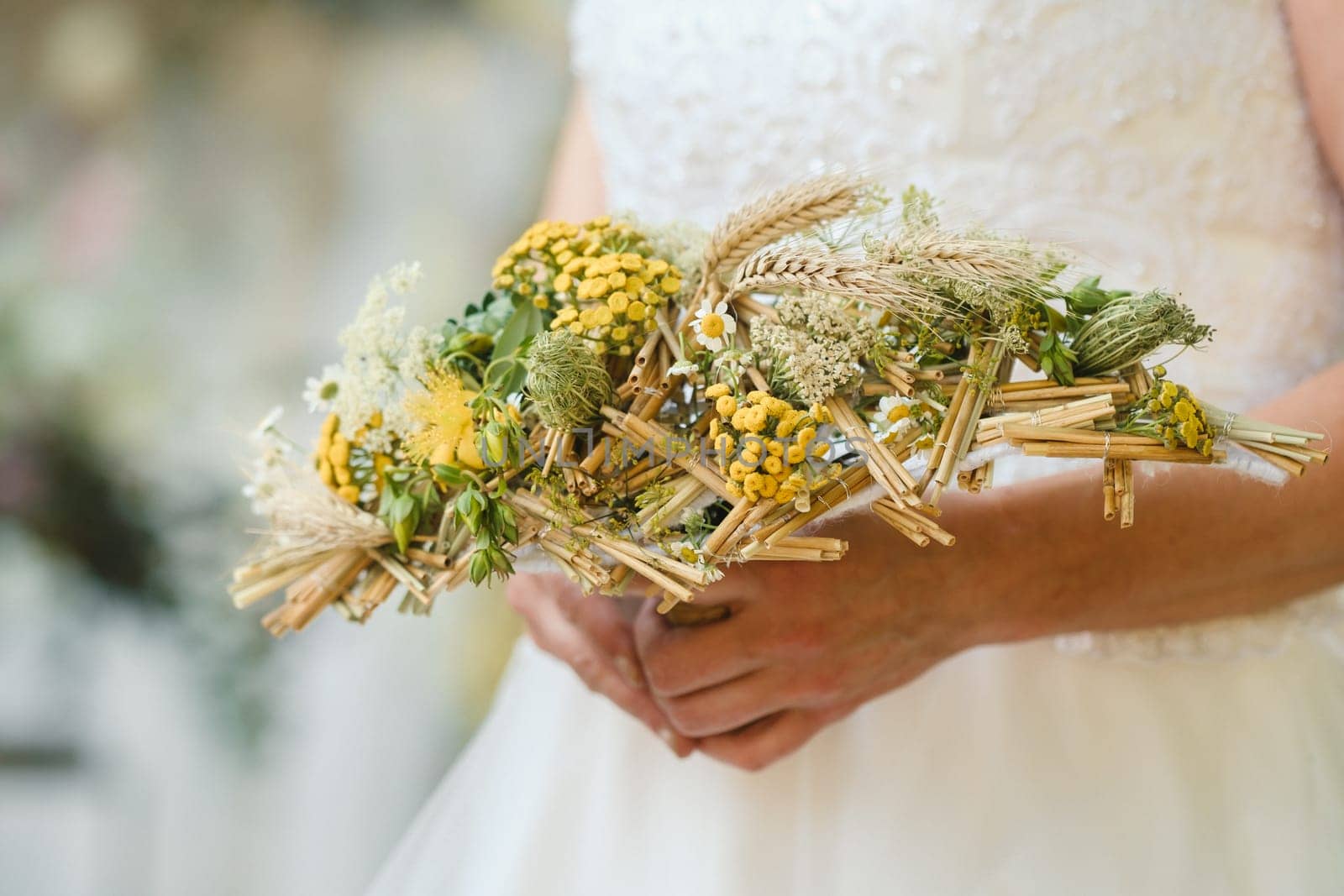 The bride holds her wedding bouquet in her hands.