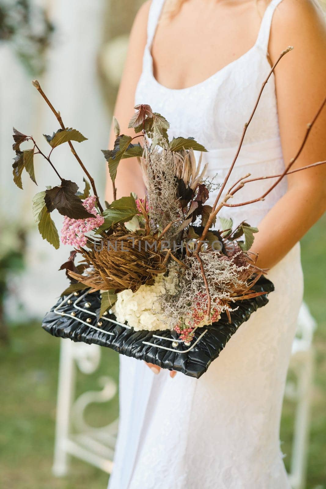 The bride holds her wedding bouquet in her hands.