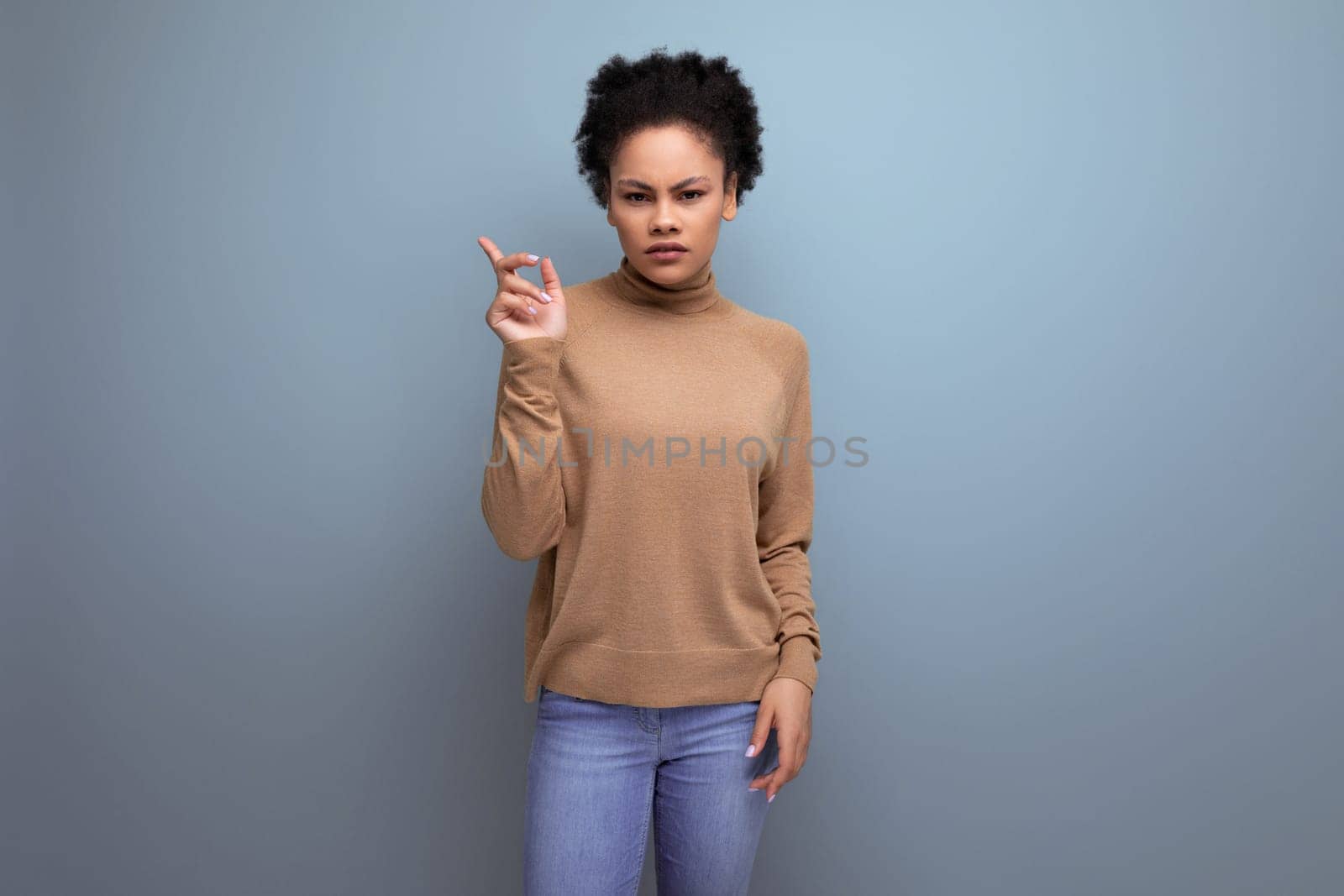 upset young woman with swarthy skin and fluffy hair over isolated background with copy space.