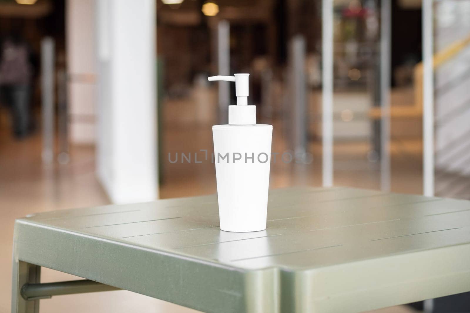 A bottle of hydroalcoholic gel at the entrance of a shop during coronavirus pandemic.