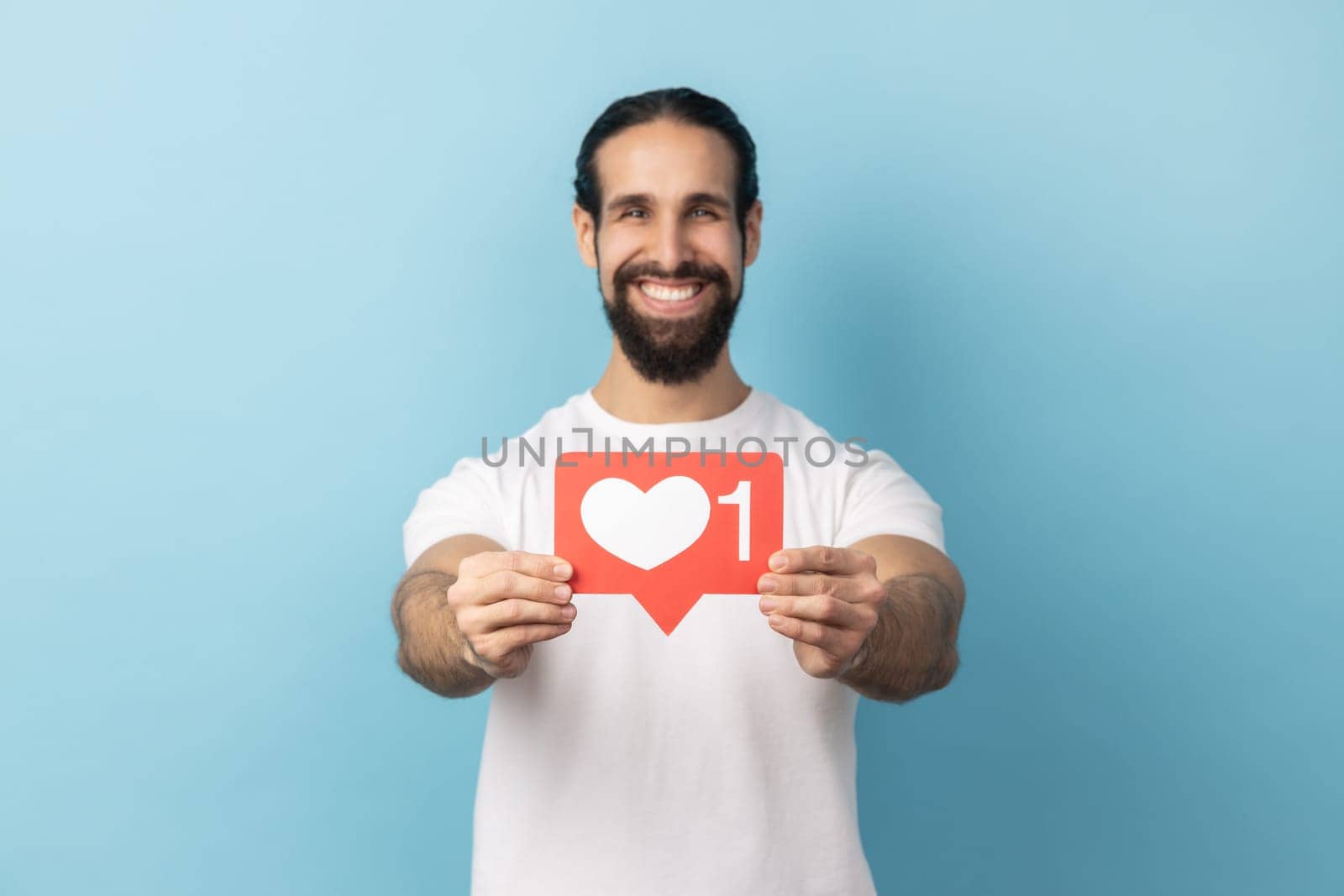 Man holding out heart like icon of social media and looking at camera with toothy smile. by Khosro1