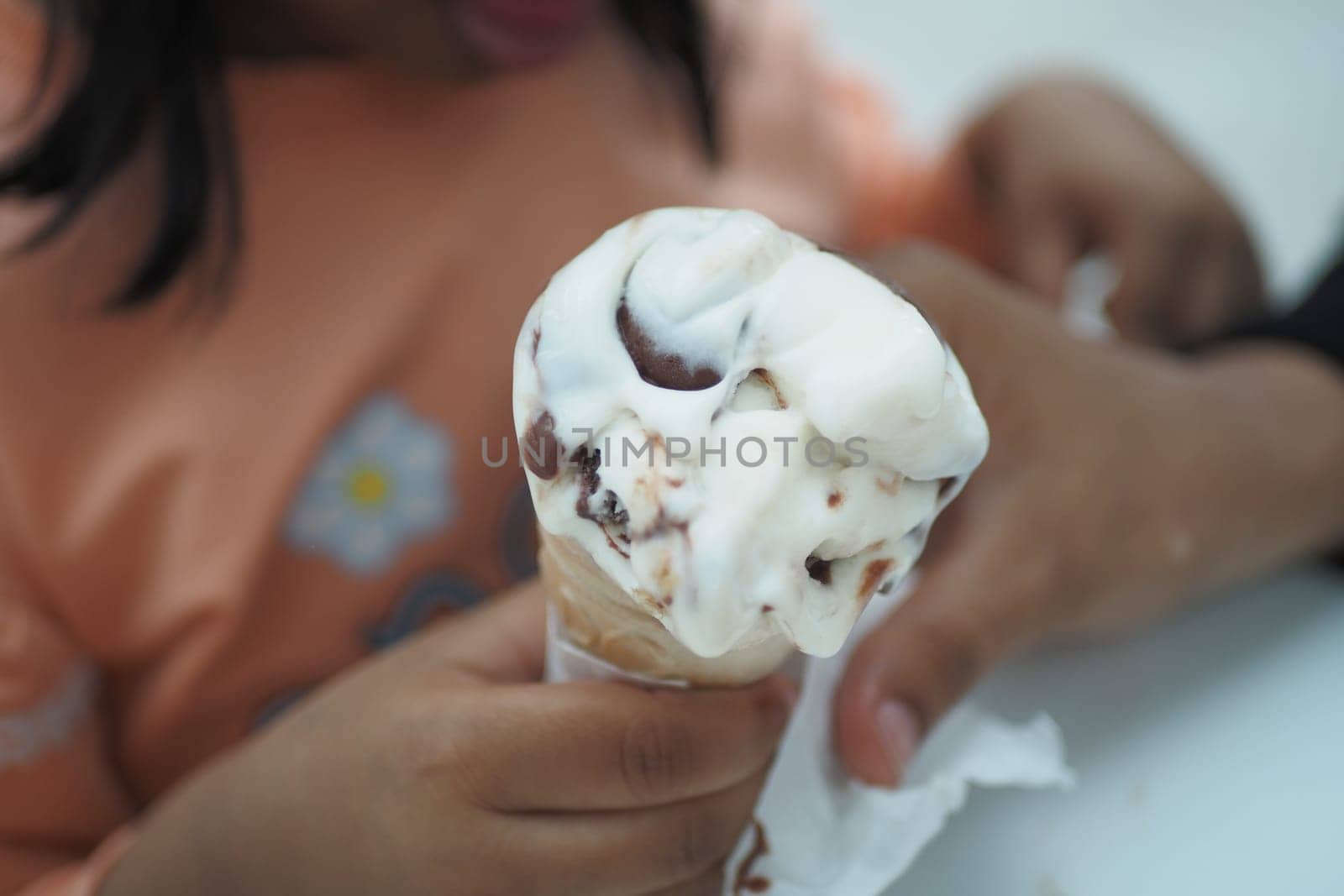 Child Hand Holding Vanilla Ice Cream in A Waffle Cone. by towfiq007