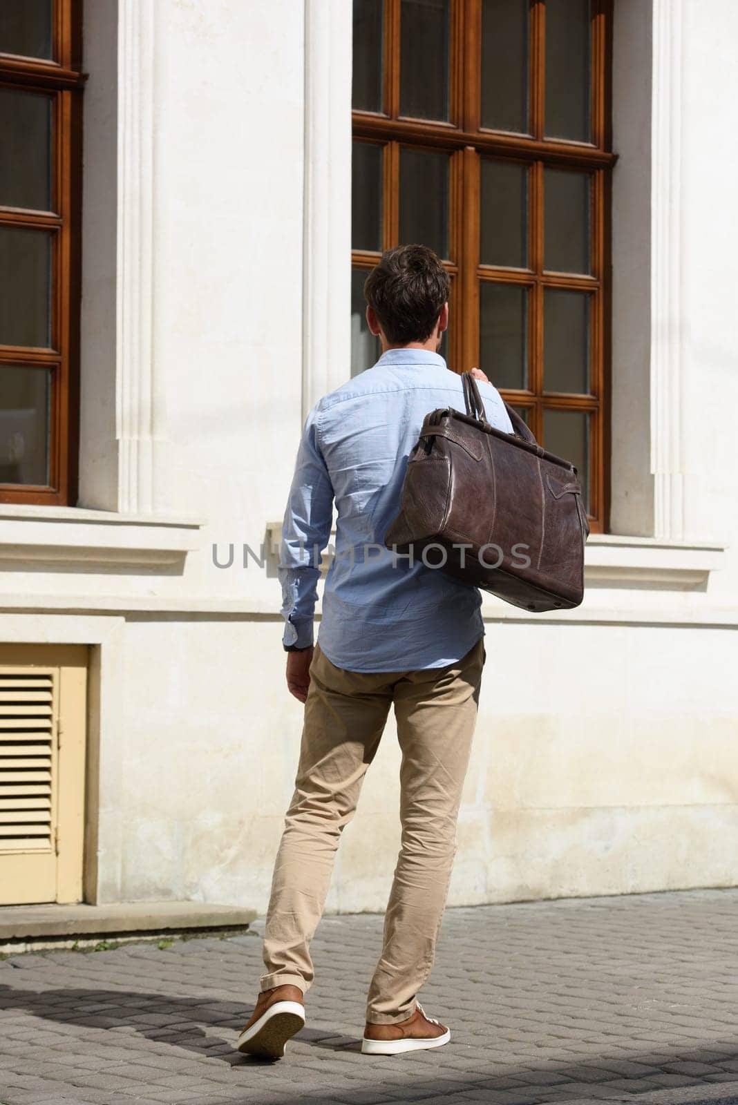 Handsome businessman walking on the street, with luxury brown leather briefcase. Fashionable style. by Ashtray25