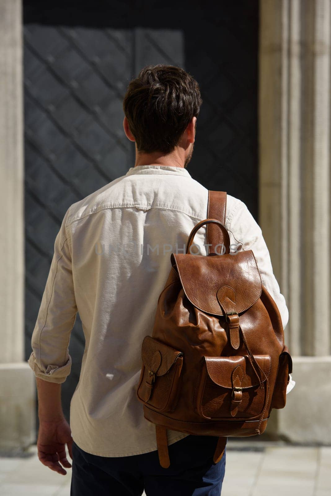 Handsome businessman walking on the street, with luxury leather brown backpack. Fashionable style. by Ashtray25