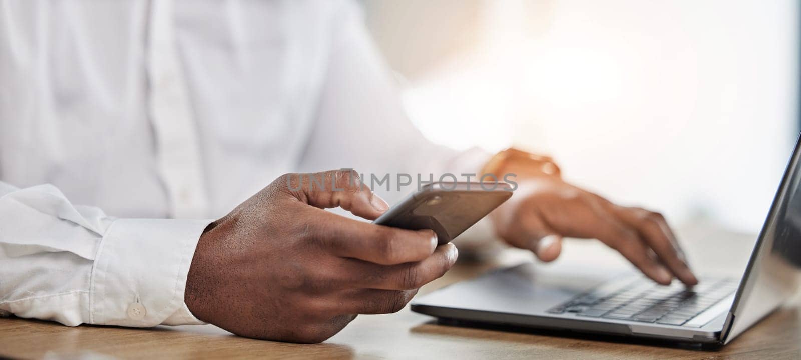 Hands, business and man with a smartphone, laptop and typing to update software, network and connection. Hand of man, employee or consultant with a pc, cellphone and search internet with app analysis.