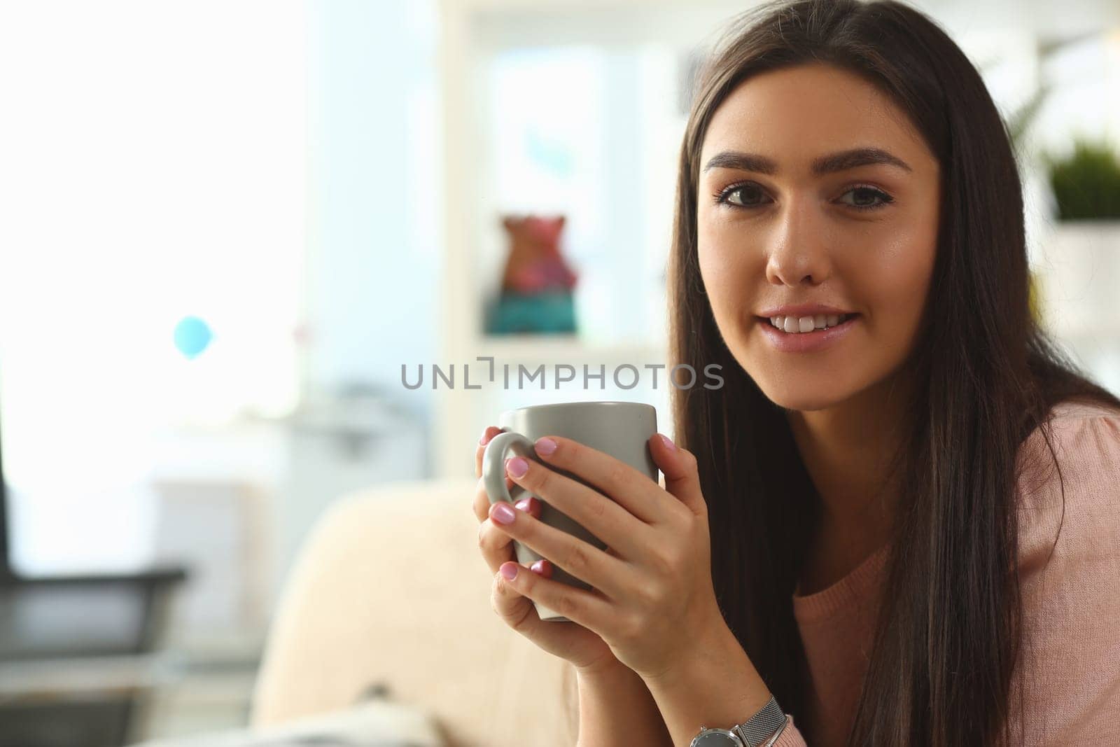 Portrait of smiling girl with cup of coffee or tea. Girl drinking hot tea and cozy at home