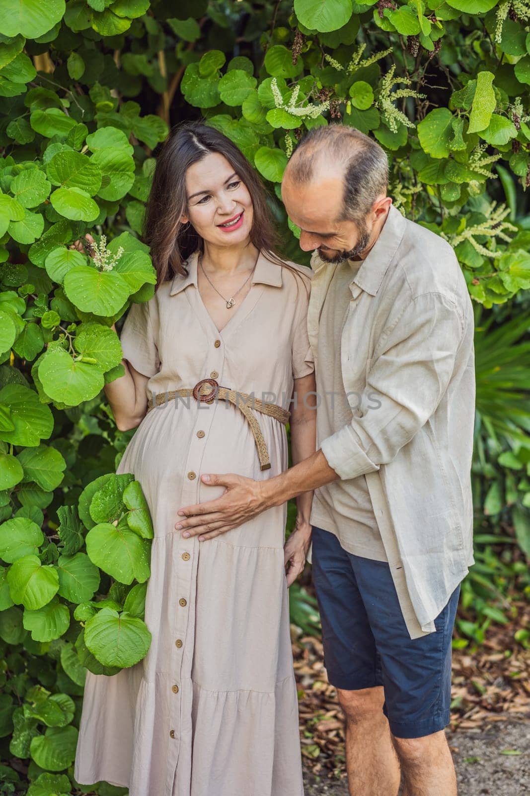 A blissful scene in the park as a radiant pregnant woman after 40 and her loving husband after 40, cherish the joy of parenthood together, surrounded by nature's serenity.