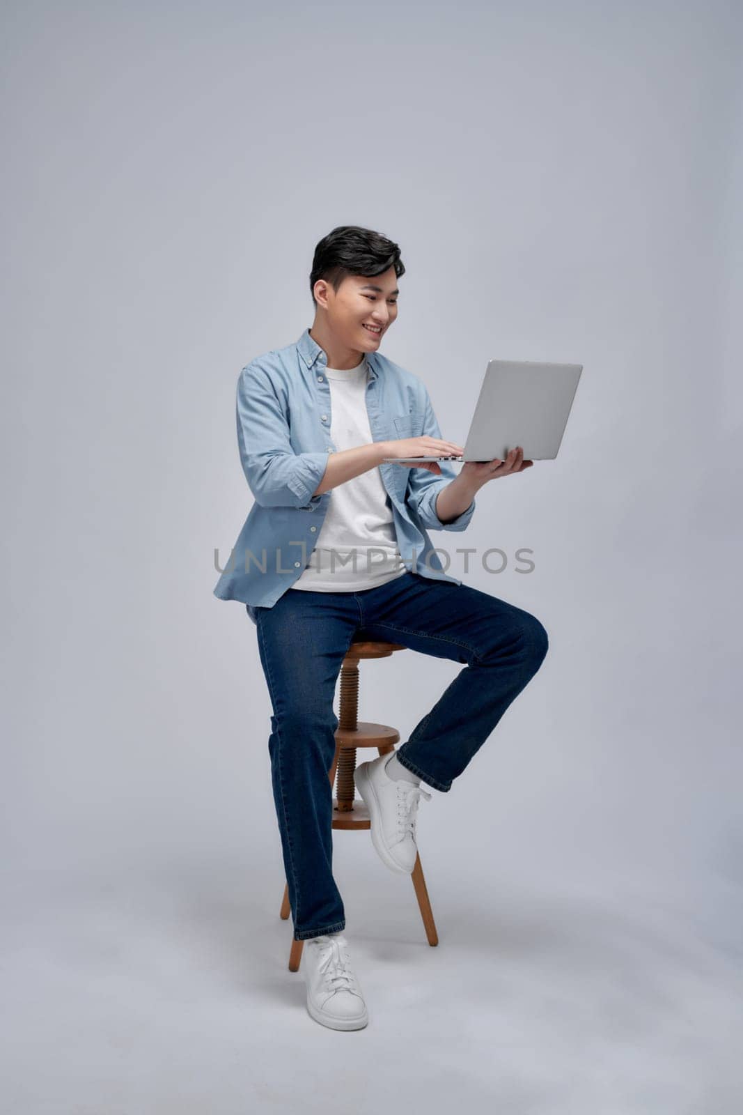 Man using laptop computer and sitting on chair  by makidotvn