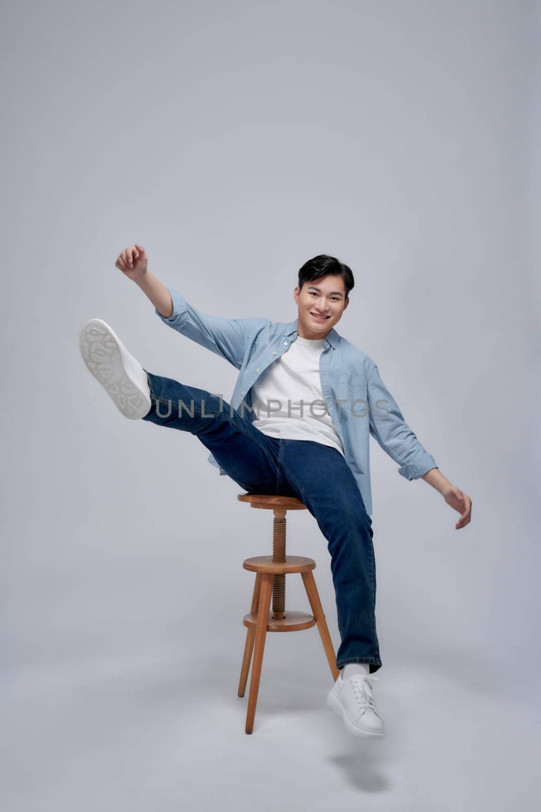 Full length of a cheerful young man sitting on chair and celebrating success  by makidotvn