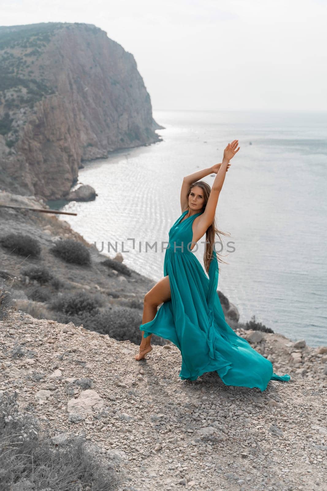 Woman sea green dress. Side view a happy woman with long hair in a long mint dress posing on a beach with calm sea bokeh lights on sunny day. Girl on the nature on blue sky background. by Matiunina