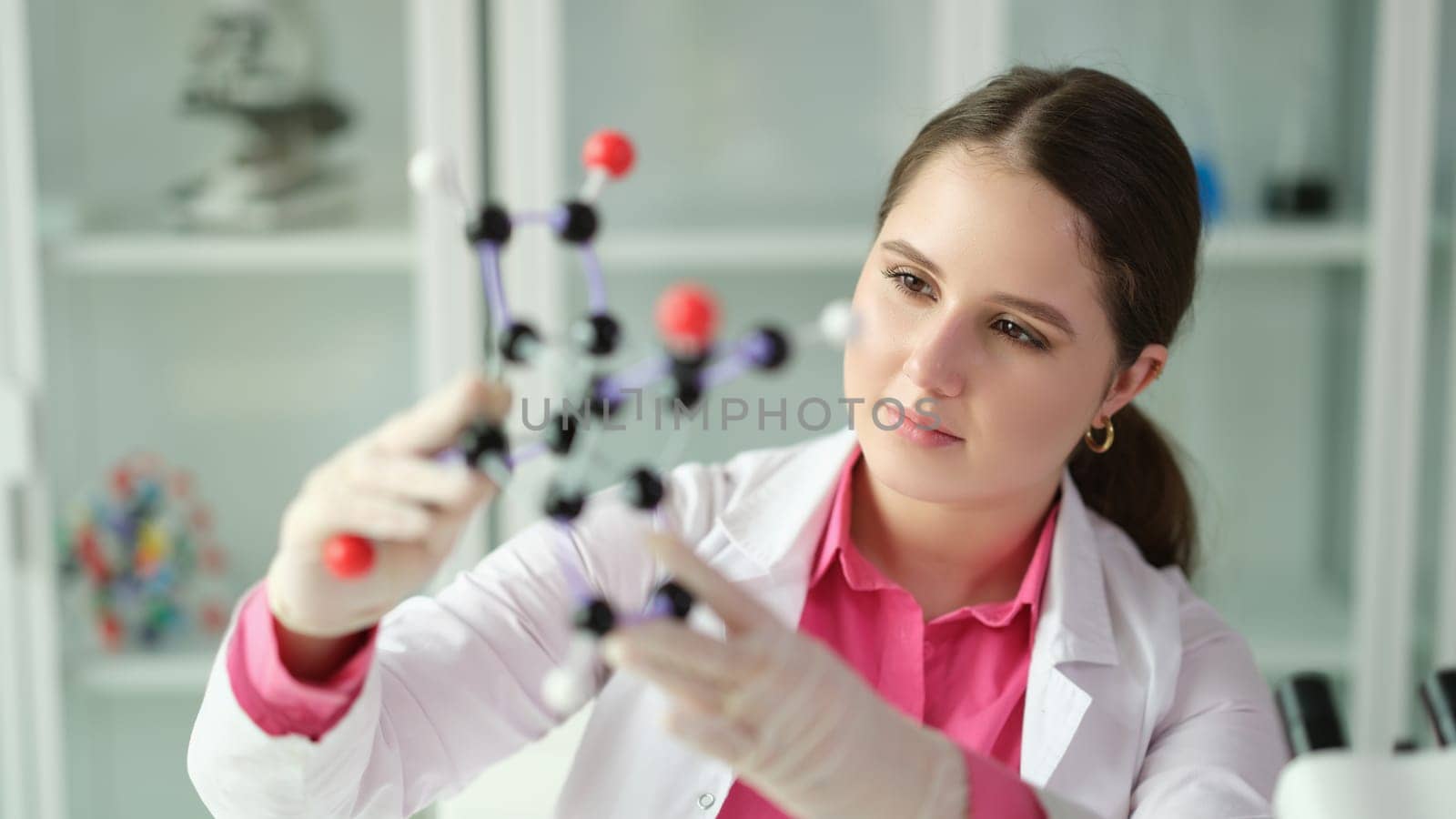 Scientist student holding a model of molecule in laboratory. Chemical and physical discoveries and study of science