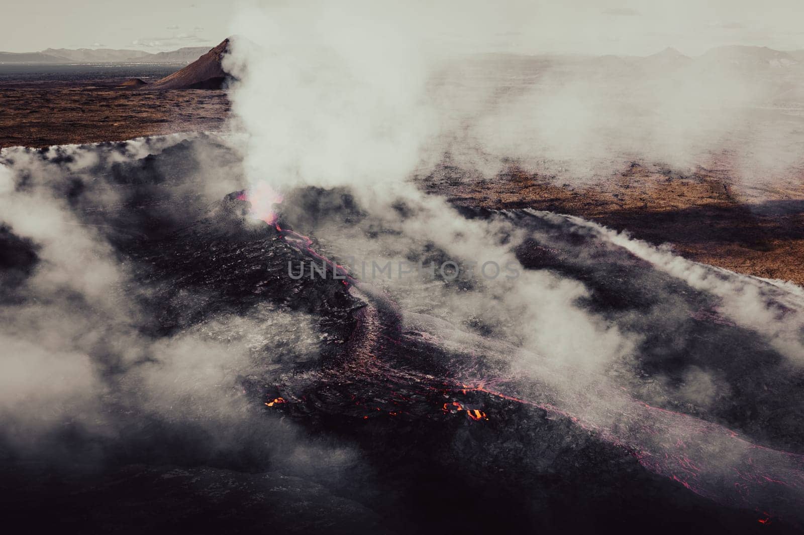 Aerial shot of a lava field of an active volcano and burned moss with a lot of smoke. by Kustov