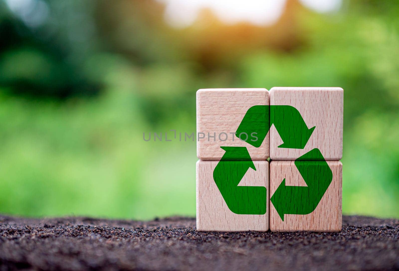 Concepts of waste reduction, pollution, reuse, efficient use of resources. Environmental protection sign by recycling on circular wooden blocks on nature background.