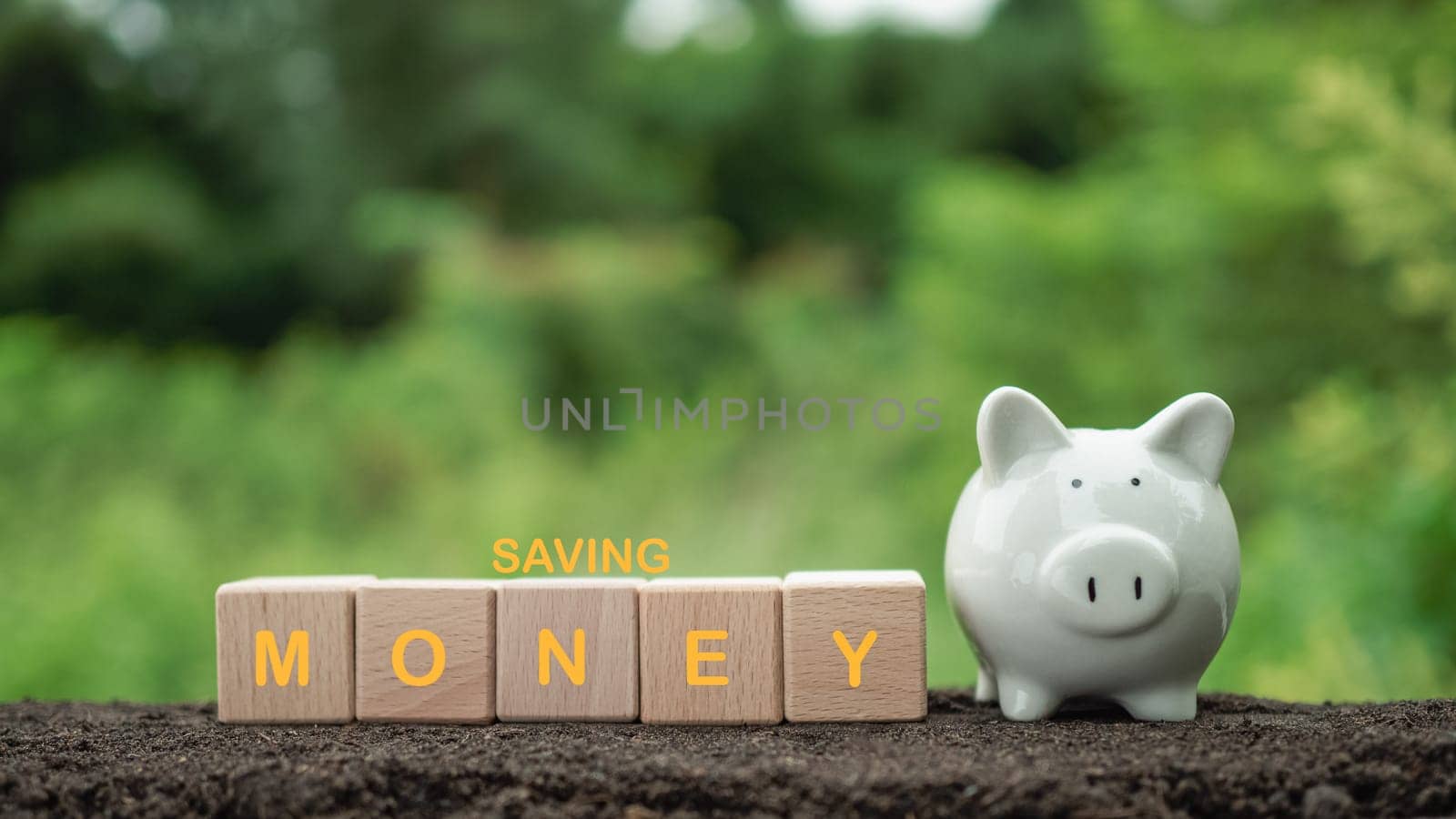 White piggy bank on nature background. Concept of savings and investment.