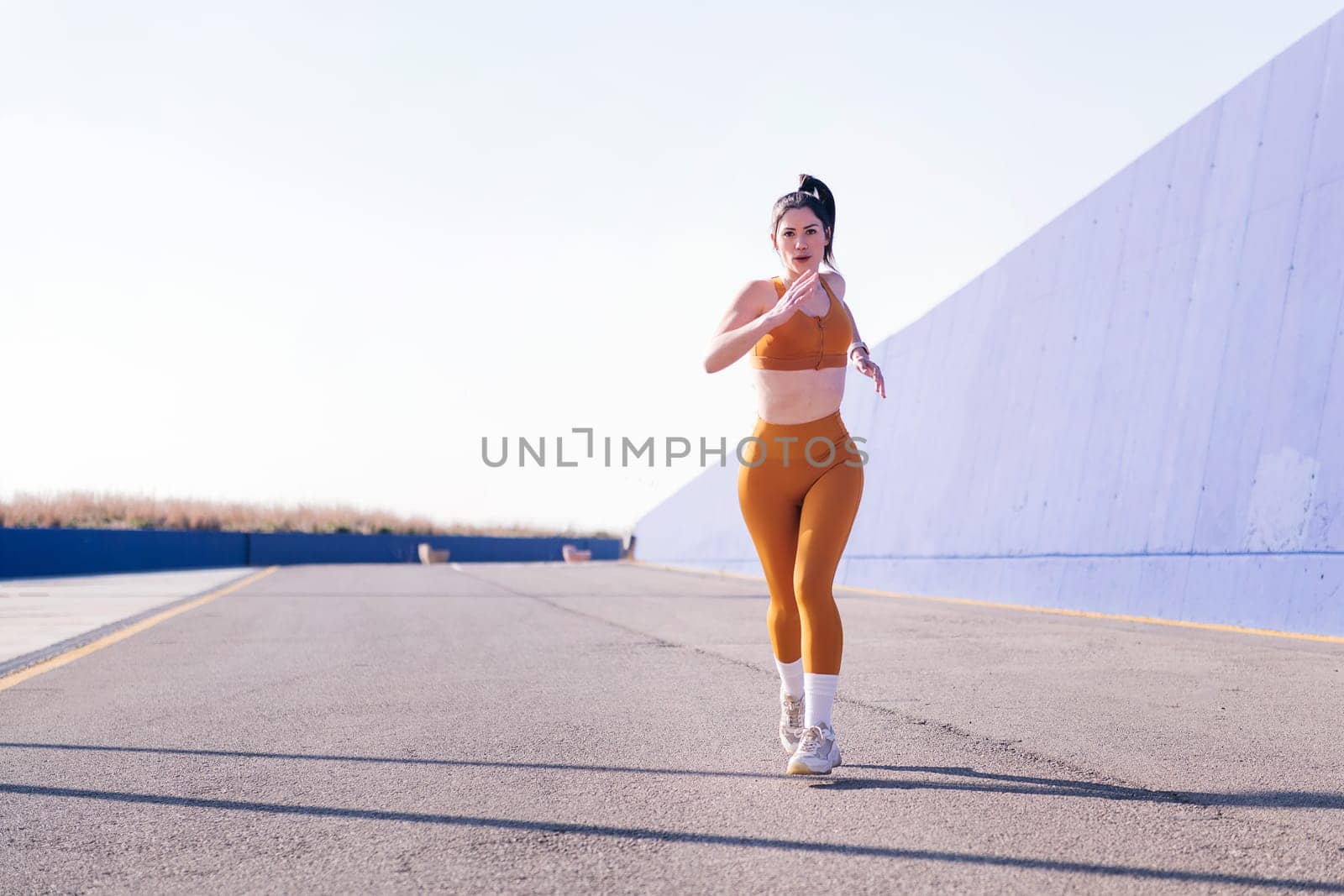 photo with motion of a caucasian sportswoman running in a athletic track, concept of sport and active lifestyle, copy space for text