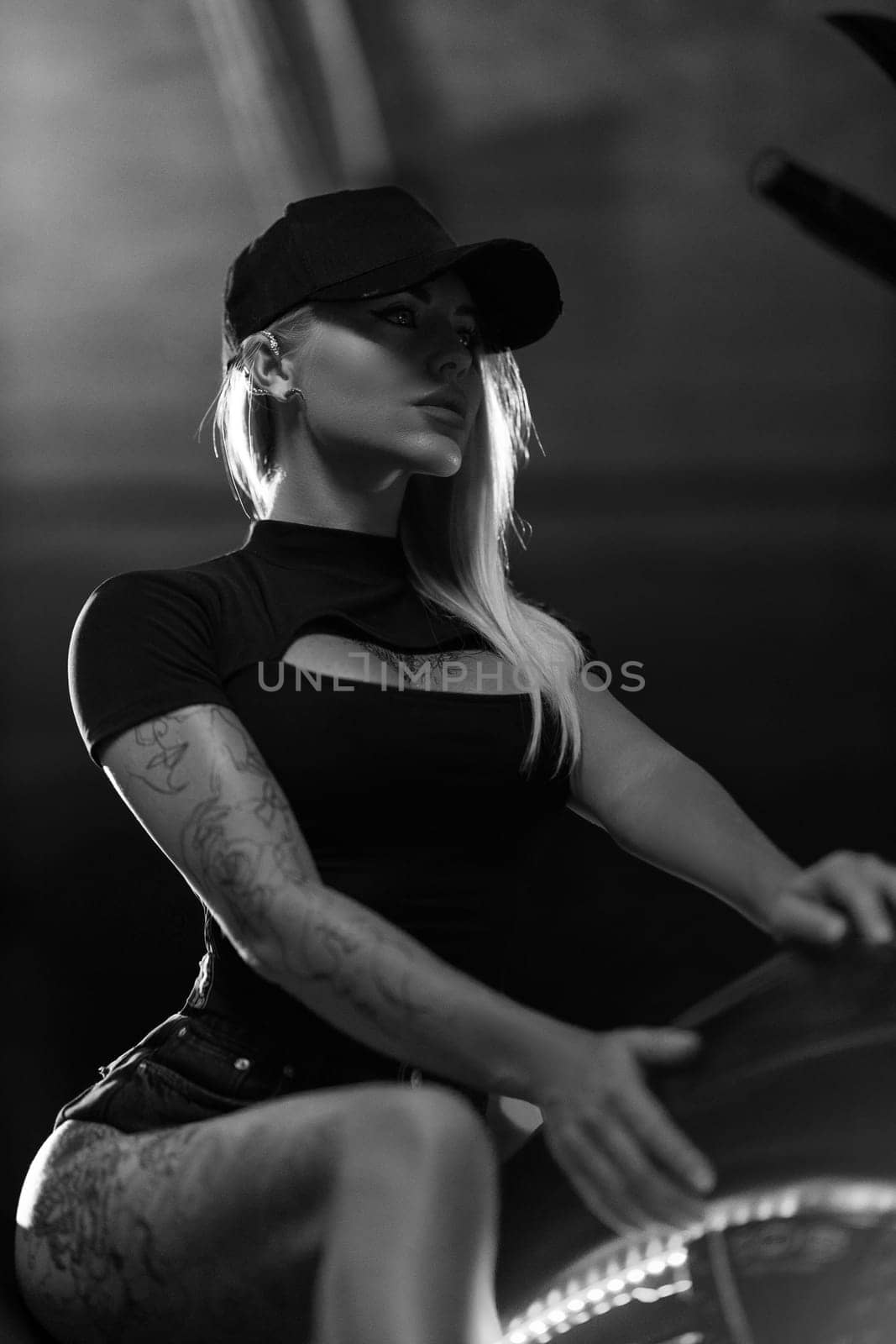 Beautiful blonde girl posing while sitting on motorcycle in the parking by but_photo